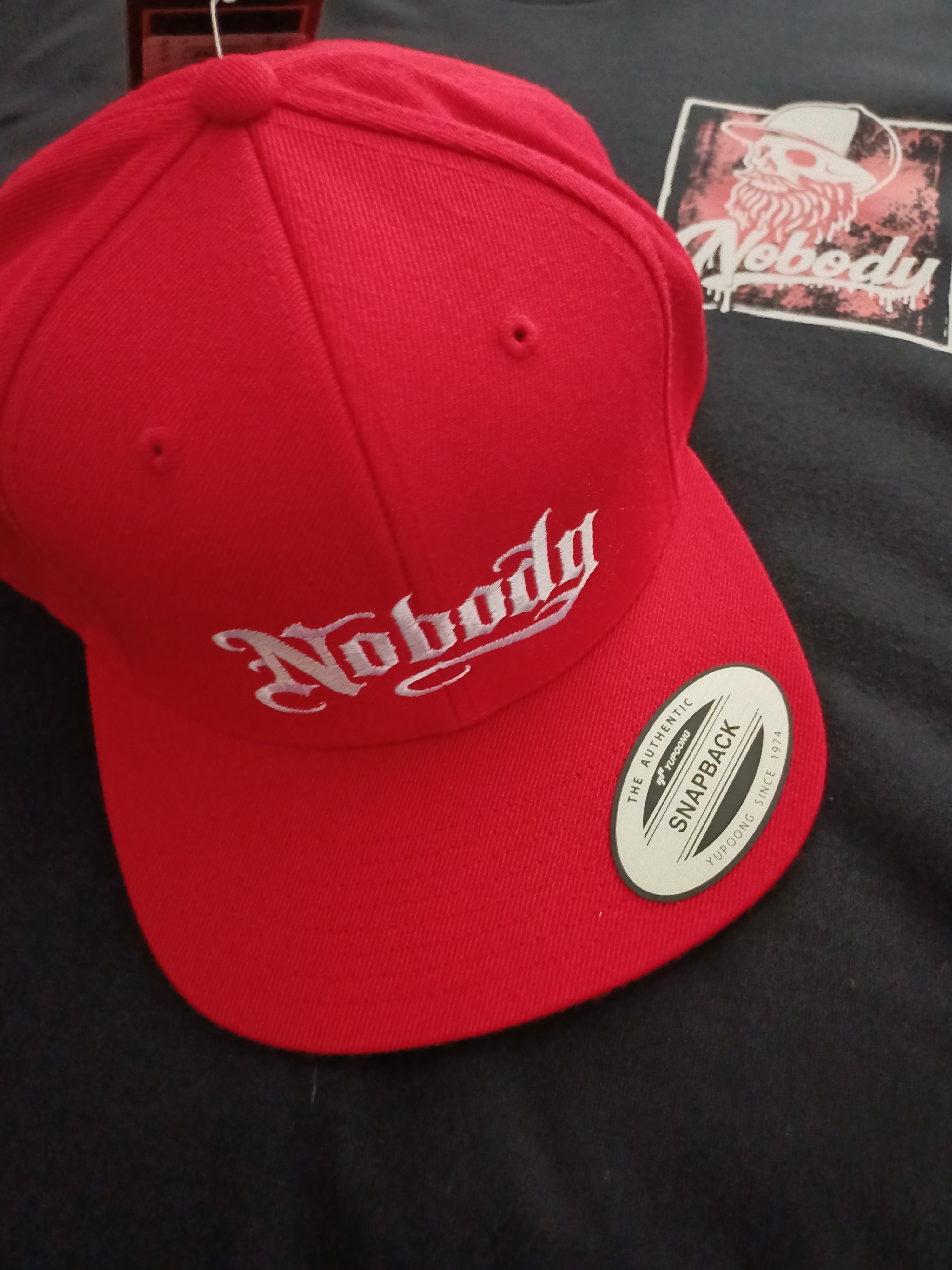 Red cap with white logo on a black background